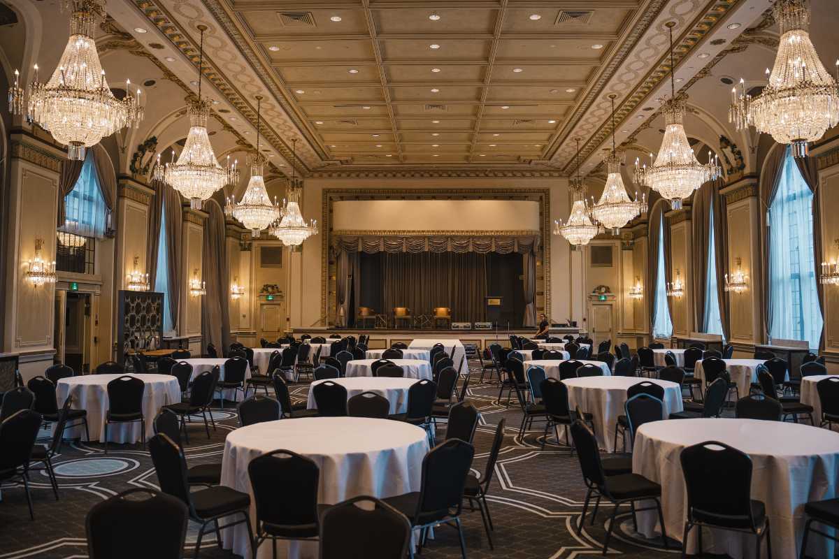Vista panoramica del porto di Porto Cesareo al tramonto, tavoli all’aperto con piatti di pesce fresco e vino bianco locale, atmosfera conviviale e rilassata